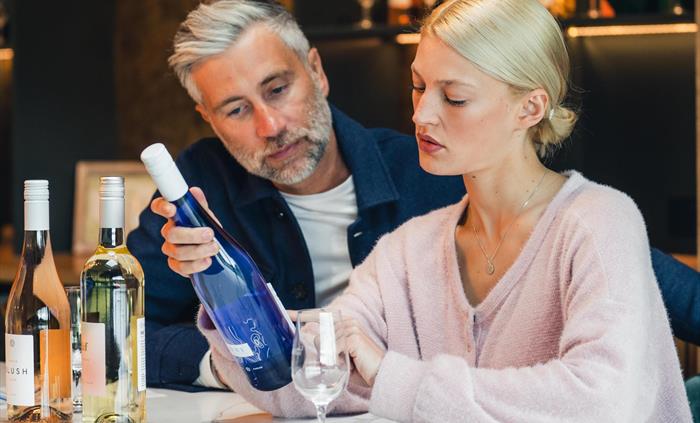 Couple Looking at Llanerch's Cariad Wine In wine tasting room